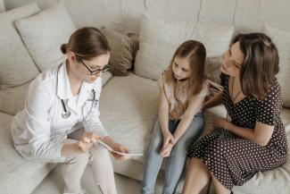 mother and daughter speaking with a doctor