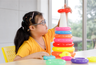 girl playing with ring stacking toy